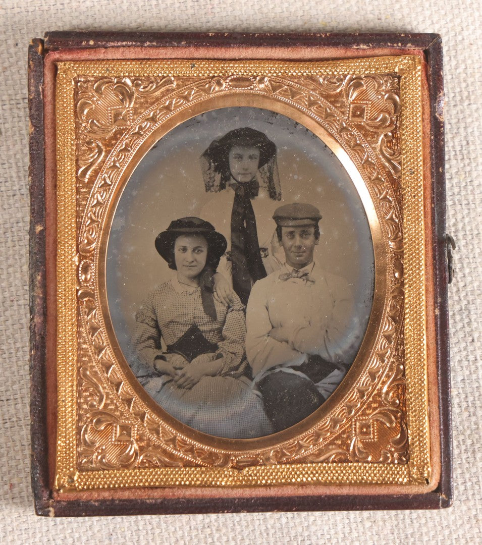 Lot 073 - Antique 1/6th Plate Ambrotype Photograph, Portrait Of Three Young People In Hats, Including Smiling Man, In Half Leatherette Case