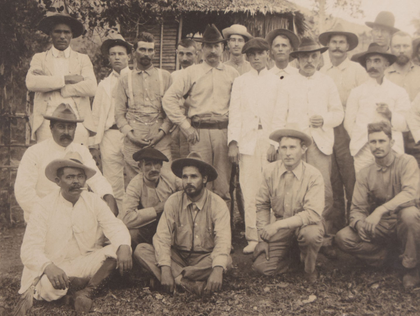 Lot 096 - Antique Board-Mounted Photograph Of A Group Of Men In A Tropical Setting With A Dog