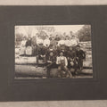 Lot 099 - Antique Board-Mounted Occupational Photograph Of A Lumber Crew, Men And Women Posed On Stacked Logs
