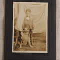 Lot 103 - Antique Board-Mounted Photograph Of A Barefoot Boy With A Dog