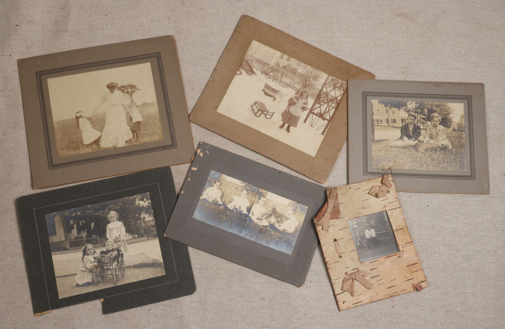 Lot 115 - Grouping Of Six Antique Board-Mounted Photographs Of Children, Including American Flag, Pet Bunnies, Pet Chickens, Doll In Pram, And Winter Sled Scene