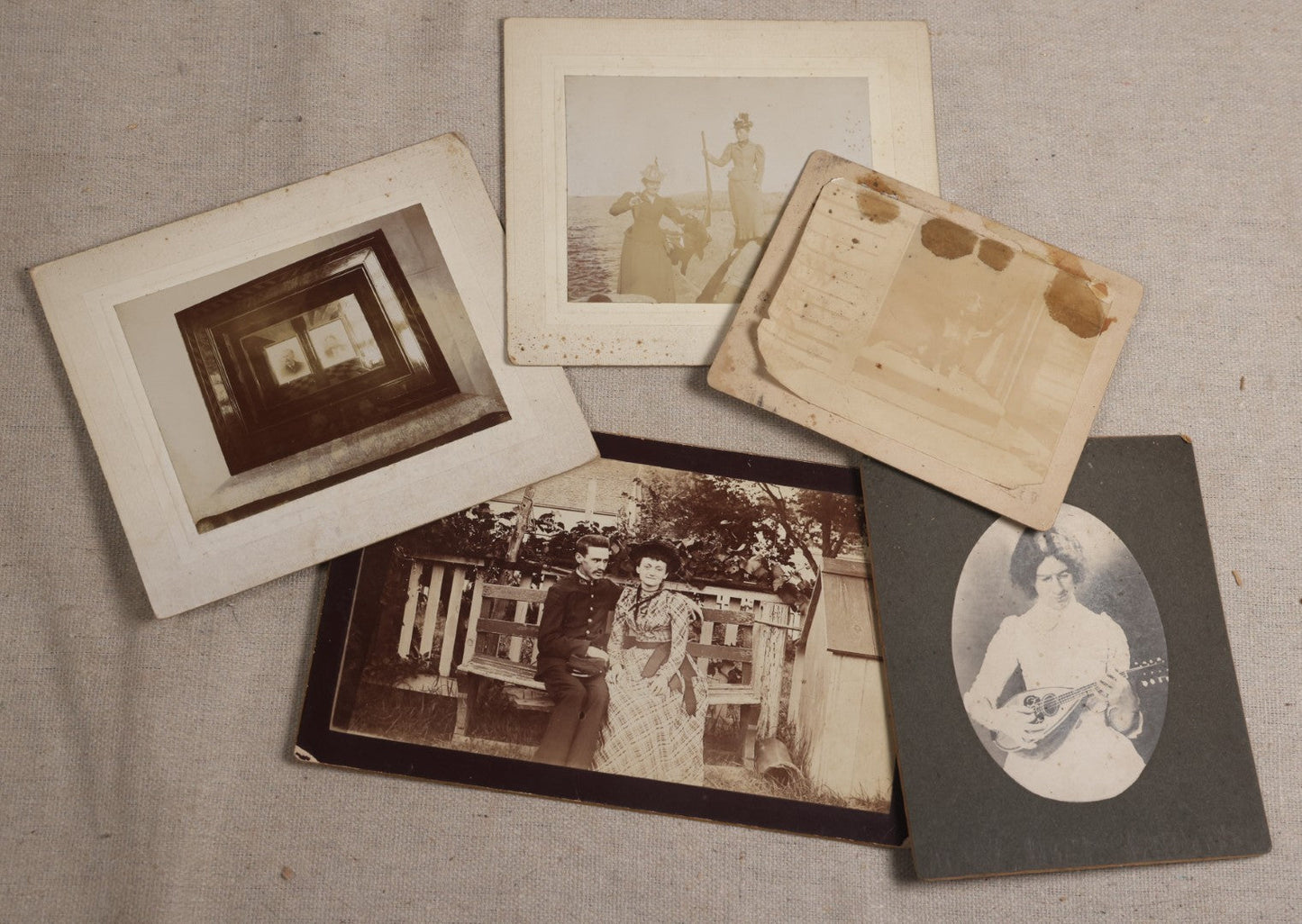 Lot 116 - Grouping Of Five Antique Board-Mounted Photographs, Including Bird Hunting With Shotguns, Woman With Lute, Uniformed Man With Horn Lapel Pin, And Dog On A Stoop
