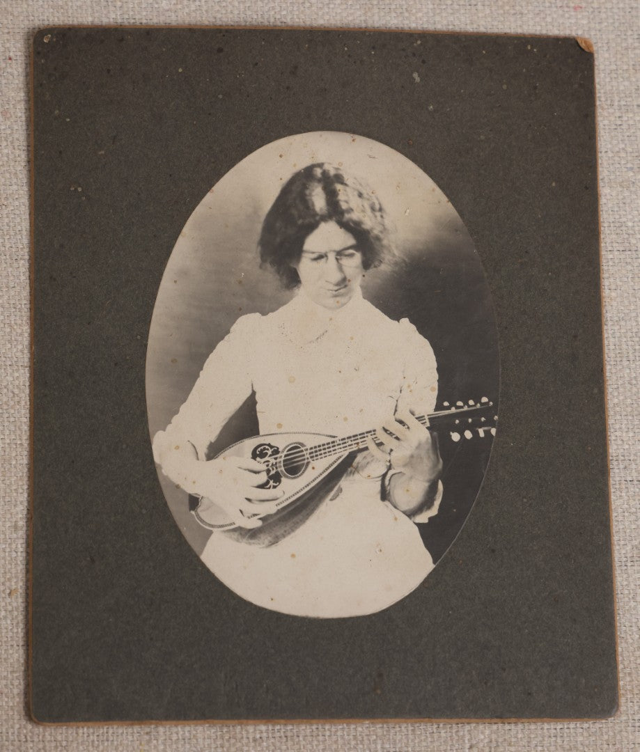 Lot 116 - Grouping Of Five Antique Board-Mounted Photographs, Including Bird Hunting With Shotguns, Woman With Lute, Uniformed Man With Horn Lapel Pin, And Dog On A Stoop