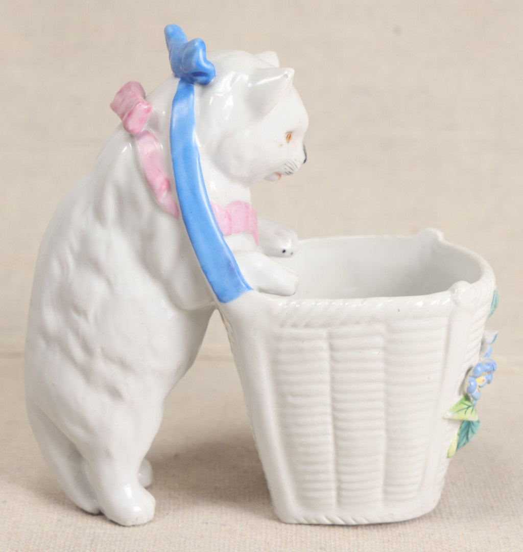 Lot 172 - Antique Porcelain Figural Cat With Basket Vase, White Cat Wearing Blue Bow And Pink Scarf With Applied Floral Decoration, Likely German
