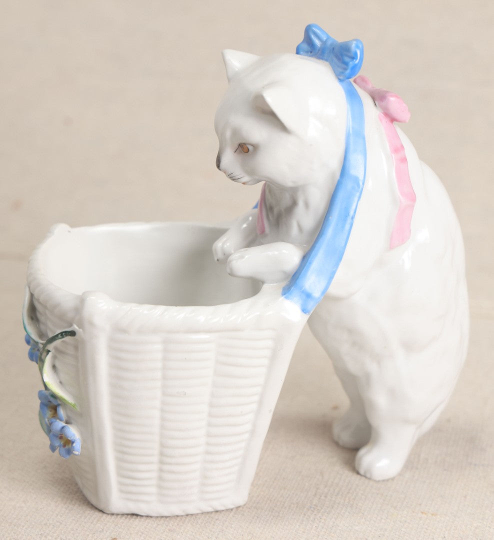 Lot 172 - Antique Porcelain Figural Cat With Basket Vase, White Cat Wearing Blue Bow And Pink Scarf With Applied Floral Decoration, Likely German