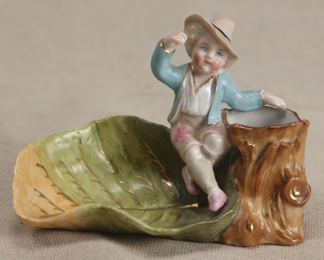 Lot 176 - Antique Porcelain Figural Match Safe And Ashtray With Boy Seated On A Tree Stump And Leaf-Form Tray