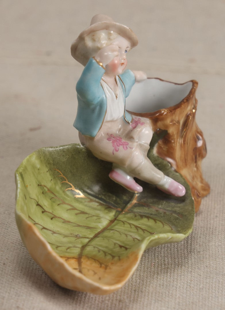 Lot 176 - Antique Porcelain Figural Match Safe And Ashtray With Boy Seated On A Tree Stump And Leaf-Form Tray