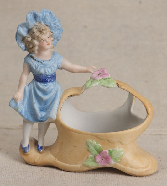 Lot 177 - Antique Bisque Figural Vase With Girl In Blue Dress Beside A Flower-Adorned Basket, Likely German