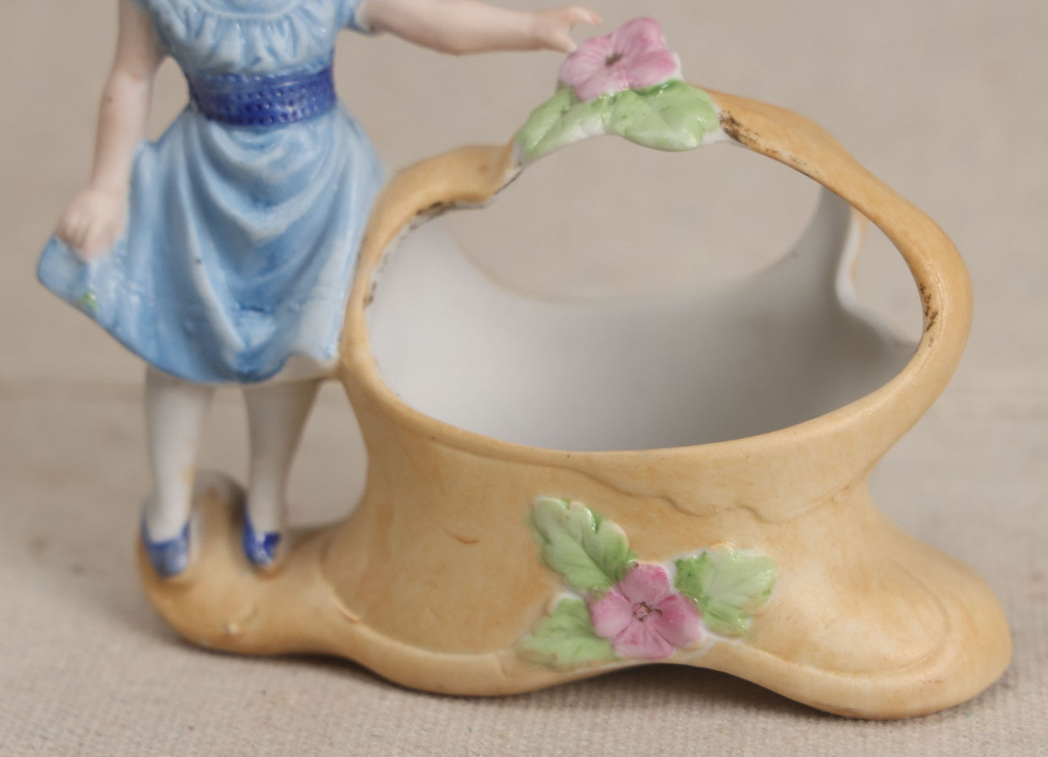 Lot 177 - Antique Bisque Figural Vase With Girl In Blue Dress Beside A Flower-Adorned Basket, Likely German