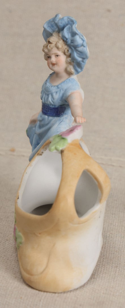 Lot 177 - Antique Bisque Figural Vase With Girl In Blue Dress Beside A Flower-Adorned Basket, Likely German