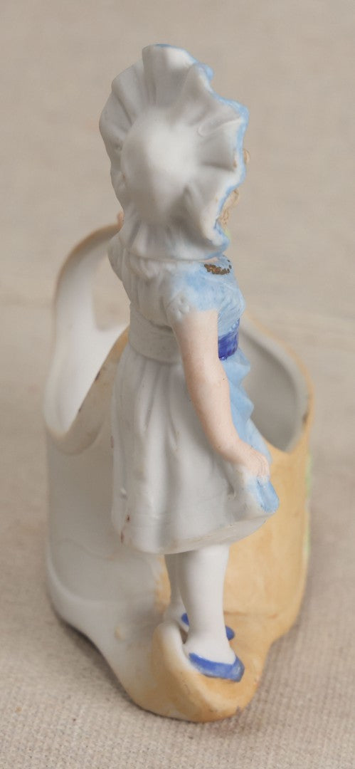 Lot 177 - Antique Bisque Figural Vase With Girl In Blue Dress Beside A Flower-Adorned Basket, Likely German