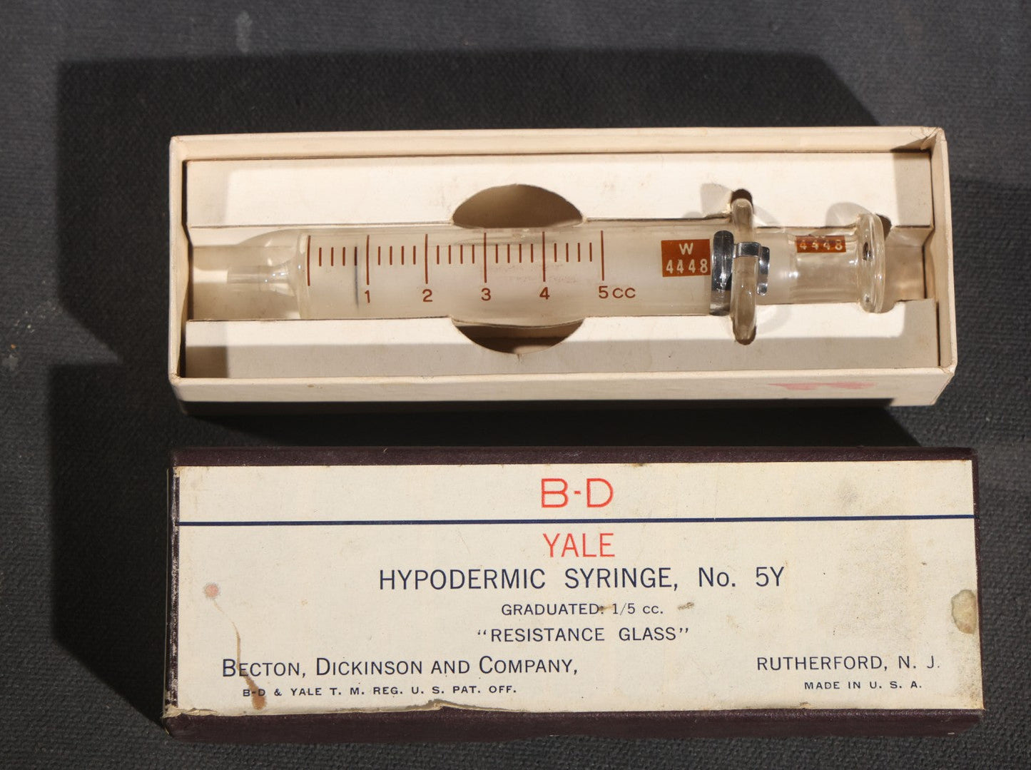 Lot 012 - Grouping Of Four Vintage Glass Medical Syringes Including Two Boxed B-D Yale Hypodermic Syringes By Becton, Dickinson And Company, Rutherford, New Jersey, One Propper Mfg. Co. 10Cc Syringe, And One B-D Yale Luer-Lok Syringe