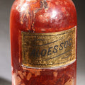 Lot 014 - Antique Apothecary Glass Jar, "Aloes Soc." (Socotrine Aloes), Reverse-Painted Gold Glass Label, Glass Stopper, Manufactured By Whitall Tatum Company, U.S.A.., 9-1/2" H