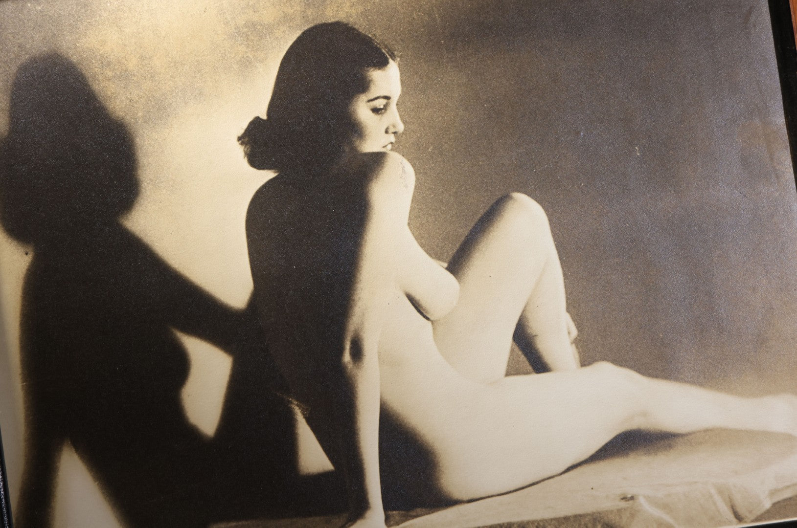 Lot 025 - Antique Framed Sepia-Tone Art Nude Photograph Of A Seated Young Woman With Dramatic Shadow, Circa 1920s-1930s
