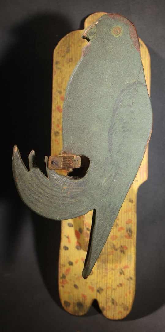Lot 035 - Antique Folk Art Painted Green Scroll-Cut Wooden Wall-Mounted Parrot On Yellow Spatter-Painted Backboard