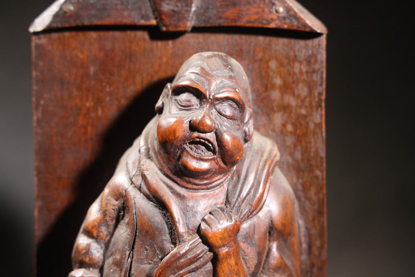 Lot 037 - Antique Folk Art Hand-Carved Wooden Figural Sculpture Of A Laughing Man With A Stein, Leaning On Books