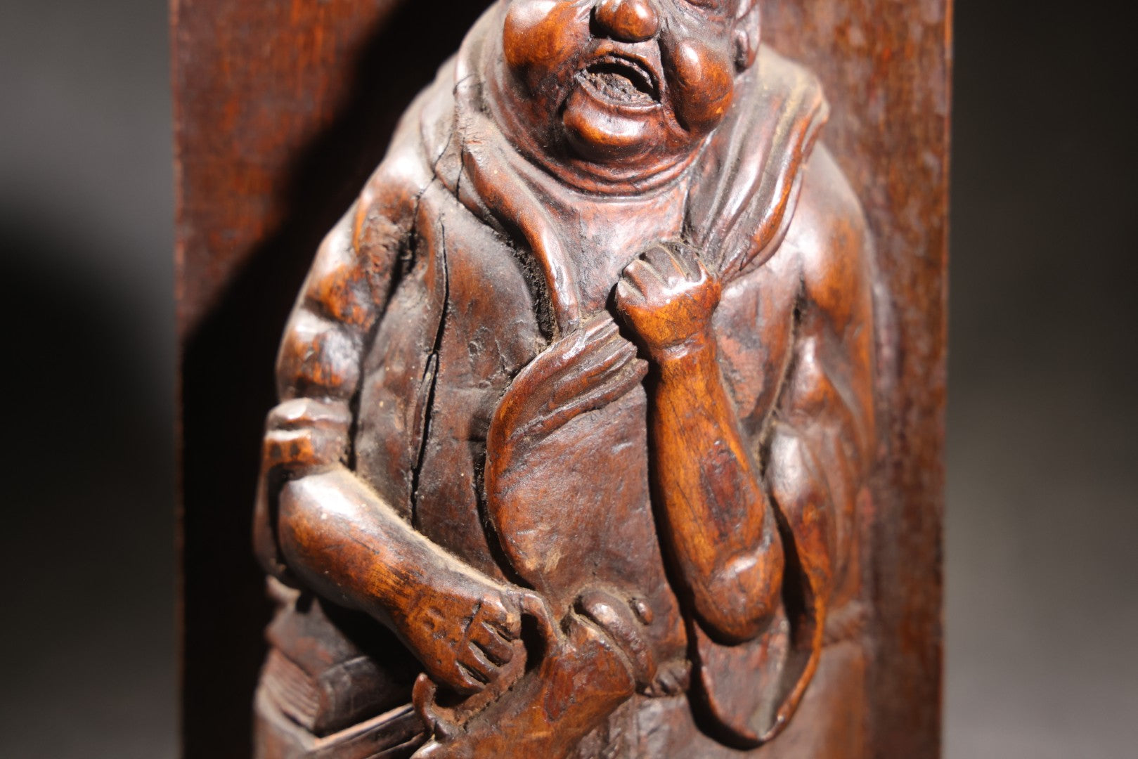 Lot 037 - Antique Folk Art Hand-Carved Wooden Figural Sculpture Of A Laughing Man With A Stein, Leaning On Books
