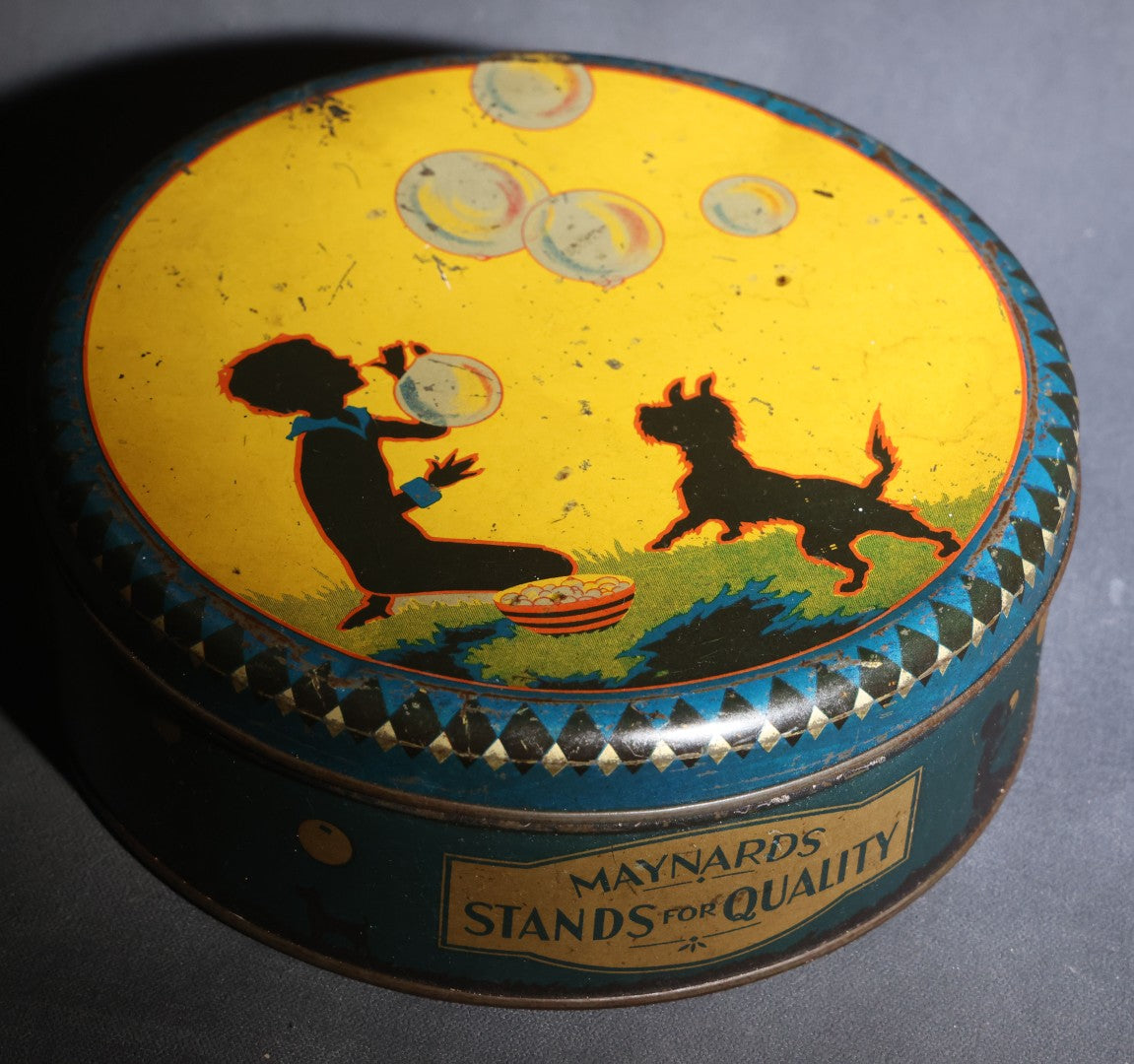 Lot 085 - Antique Maynards "Stands For Quality" Tin Lithograph Candy Tin With Silhouette Graphics Of Child Blowing Bubbles With Dog