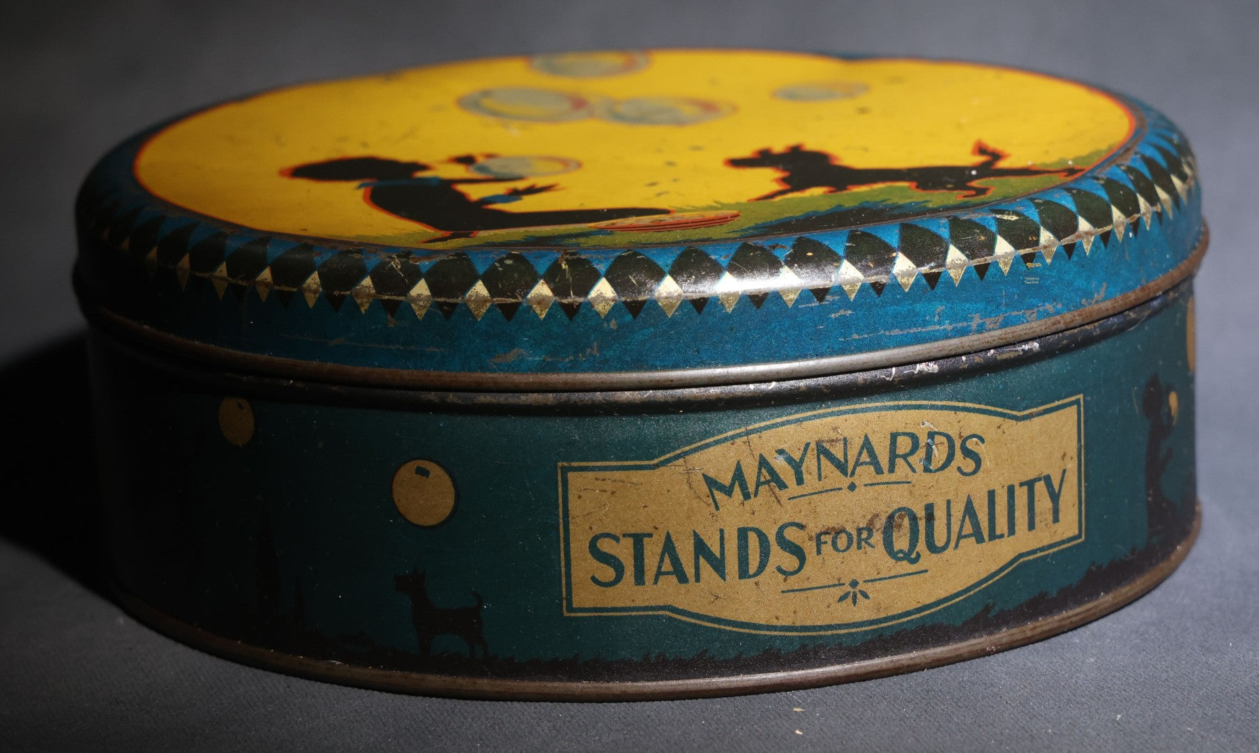 Lot 085 - Antique Maynards "Stands For Quality" Tin Lithograph Candy Tin With Silhouette Graphics Of Child Blowing Bubbles With Dog