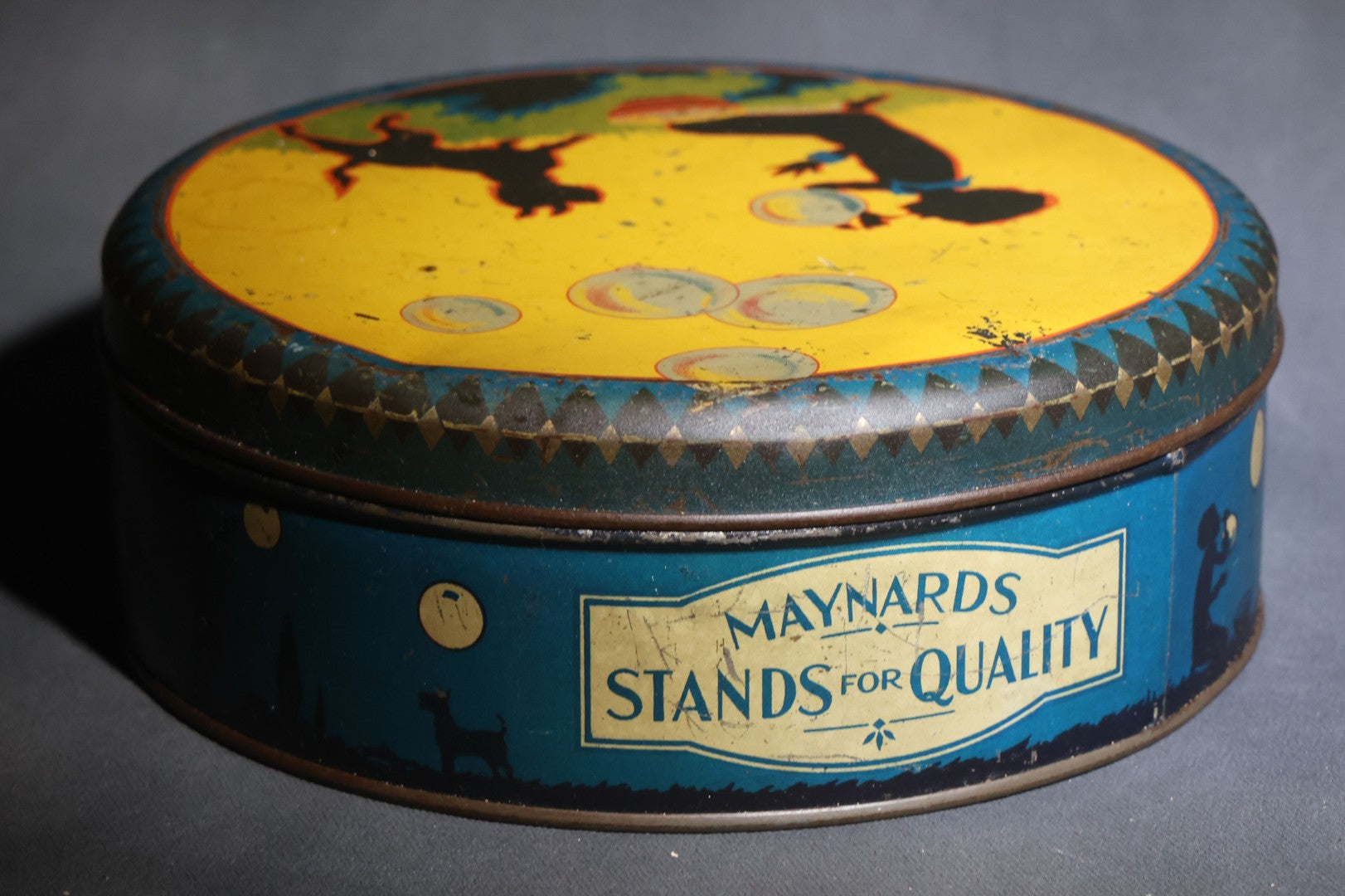 Lot 085 - Antique Maynards "Stands For Quality" Tin Lithograph Candy Tin With Silhouette Graphics Of Child Blowing Bubbles With Dog