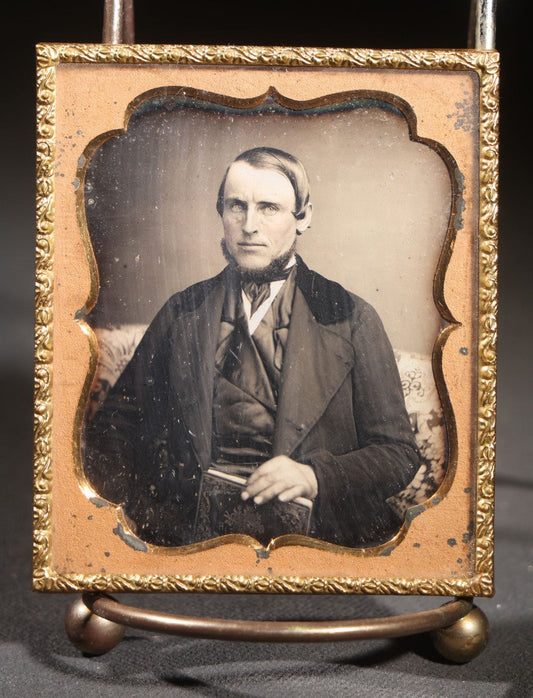 Lot 112 - Antique 1/6th Plate Daguerreotype Photograph, Uncased, Portrait Of A Middle-Aged Man With Chin Beard Holding A Book, Cartouche-Form Brass Mat