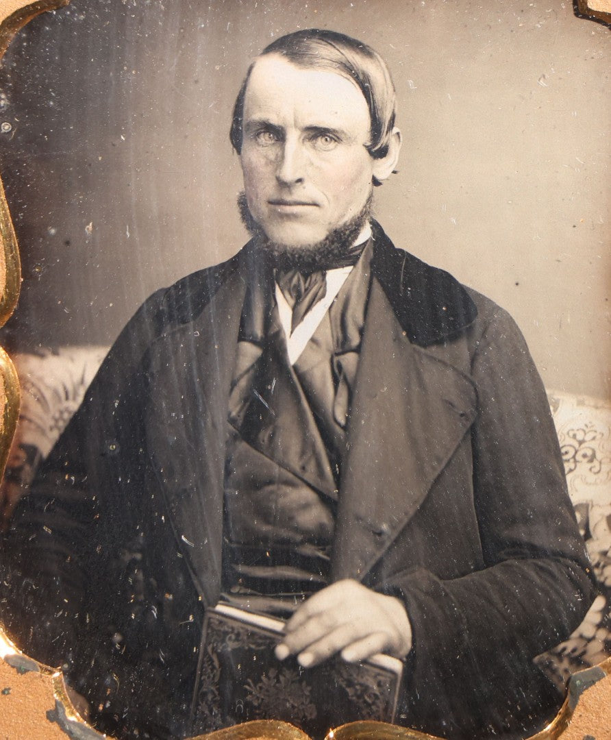Lot 112 - Antique 1/6th Plate Daguerreotype Photograph, Uncased, Portrait Of A Middle-Aged Man With Chin Beard Holding A Book, Cartouche-Form Brass Mat