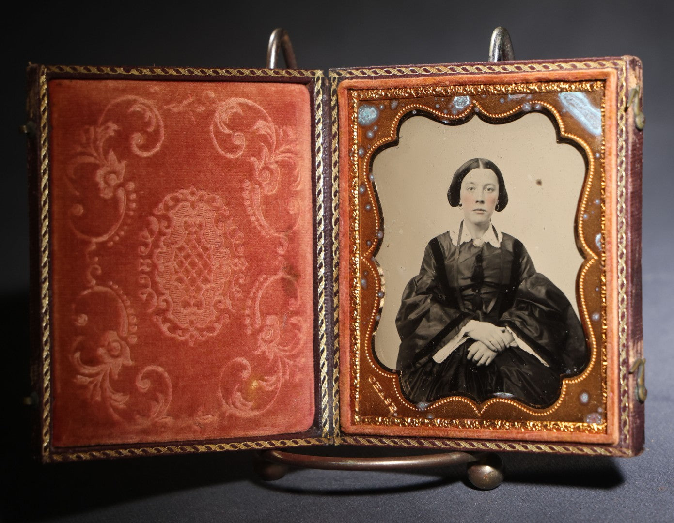 Lot 117 - Antique 1/6th Plate Ruby Ambrotype Photograph, Full Intact Leatherette Union Case, Young Woman In Dark Dress With Crossed Hands, Embossed Thistle And Floral Case Design