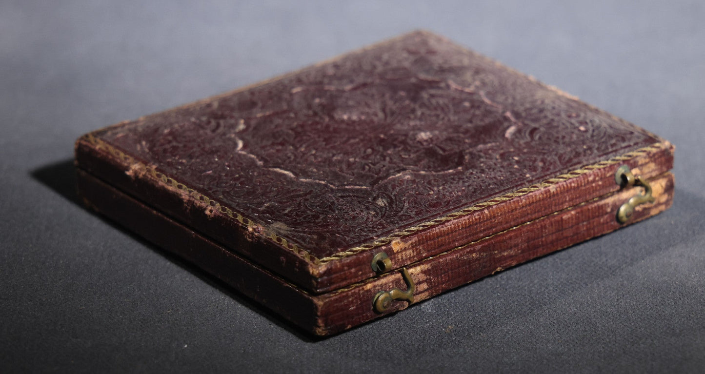 Lot 117 - Antique 1/6th Plate Ruby Ambrotype Photograph, Full Intact Leatherette Union Case, Young Woman In Dark Dress With Crossed Hands, Embossed Thistle And Floral Case Design
