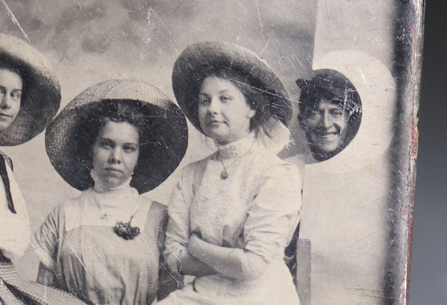 Lot 120 - Antique Tintype Photograph Of Five Young Women In Wide-Brimmed Hats With Parasols, Man Peeking Through Hole In Studio Backdrop, Seaside Scene