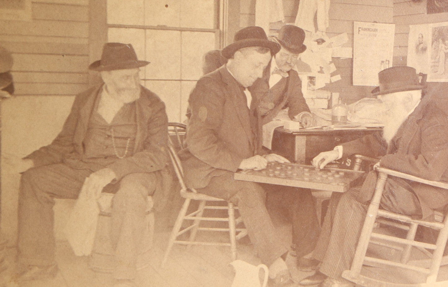 Lot 130 - Antique Boudoir-Size Cabinet Card Photograph Of Three Men Playing Checkers In A Store Interior With Pot-Belly Stove, Calendars, And Rocking Chair, Pencil-Inscribed "Uncle Ed"