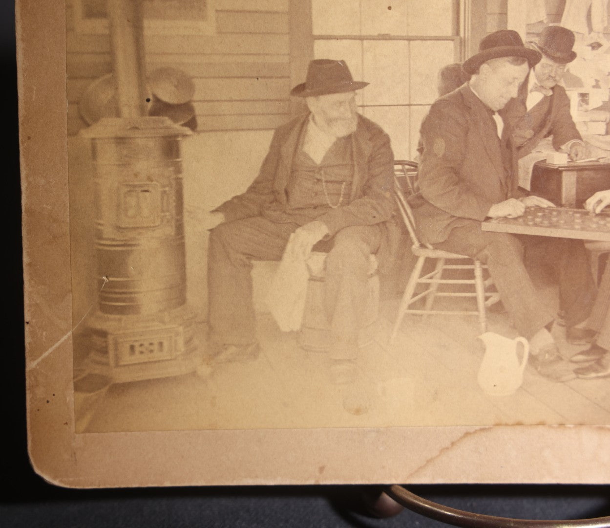 Lot 130 - Antique Boudoir-Size Cabinet Card Photograph Of Three Men Playing Checkers In A Store Interior With Pot-Belly Stove, Calendars, And Rocking Chair, Pencil-Inscribed "Uncle Ed"