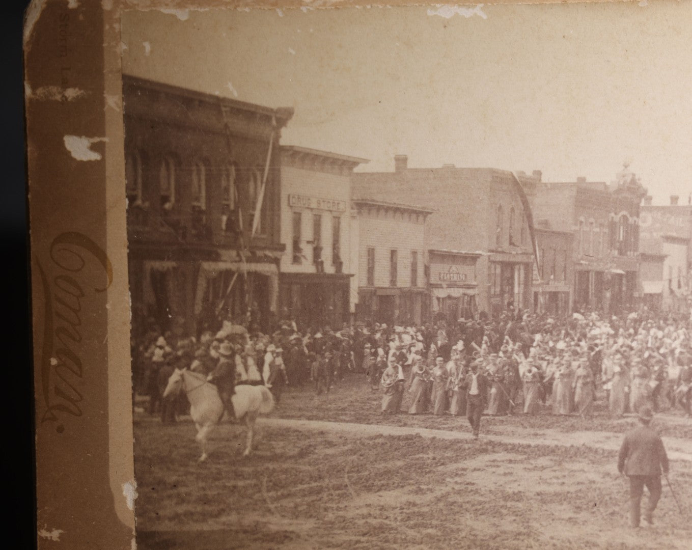 Lot 131 - Antique Board-Mounted Panoramic Photograph Of A Parade On Main Street, Storm Lake, Iowa, Photographed By Coman, Crowds, Horseback Rider, And American Flag