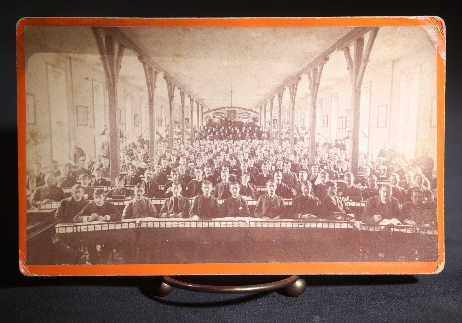 Lot 132 - Antique Board-Mounted Photograph Of A Large Assembly Hall Interior With Rows Of Seated Young Men, Banners For Eastmore College, Bank Of Poughkeepsie, And Tenth National Bank Of Boston