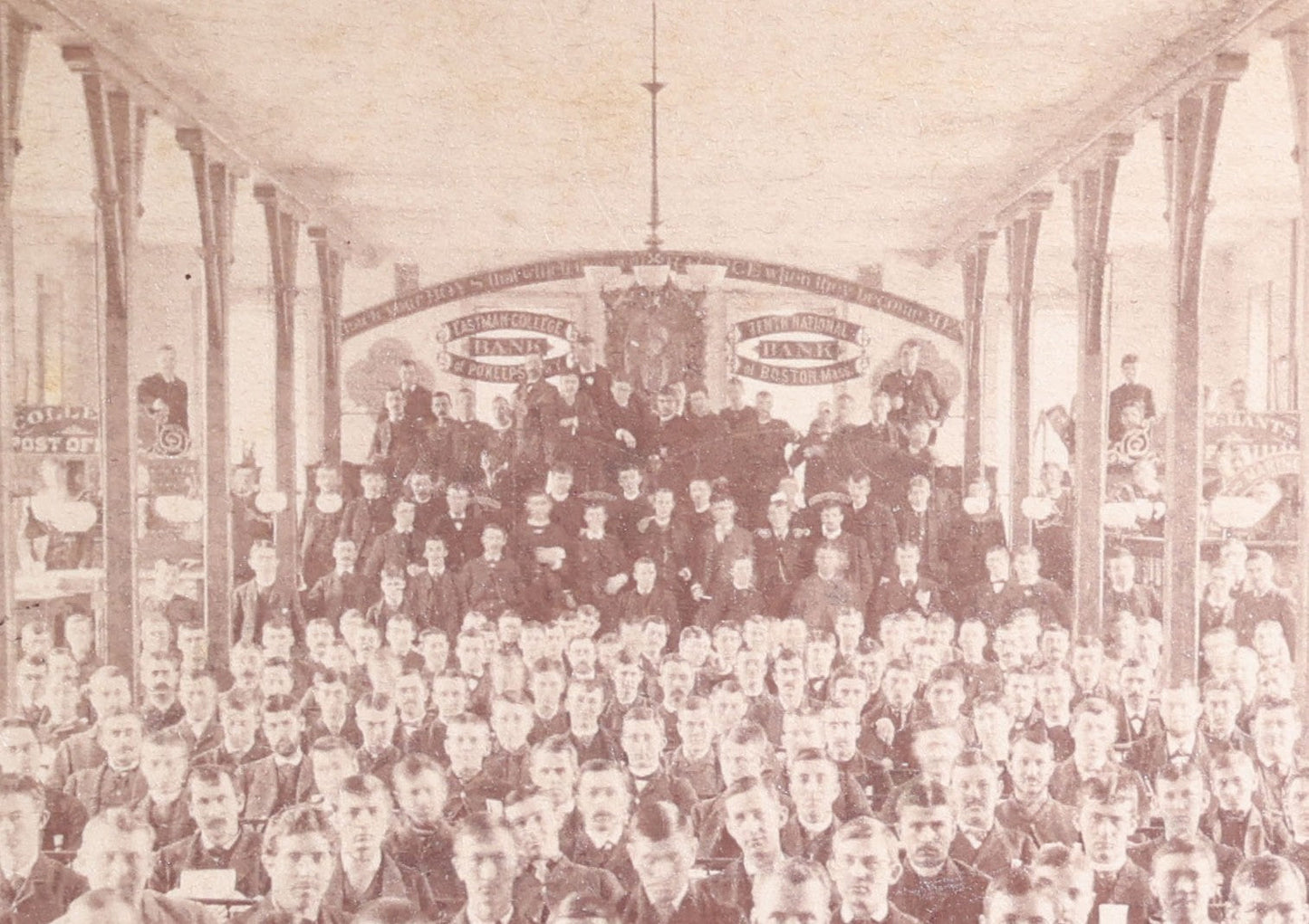 Lot 132 - Antique Board-Mounted Photograph Of A Large Assembly Hall Interior With Rows Of Seated Young Men, Banners For Eastmore College, Bank Of Poughkeepsie, And Tenth National Bank Of Boston