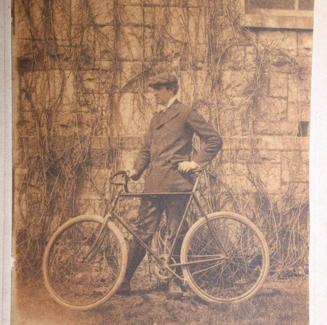 Lot 133 - Antique Cabinet Card Photograph Of A Young Man In A Suit And Cap Posed With A Bicycle Before A Vine-Covered Stone Wall