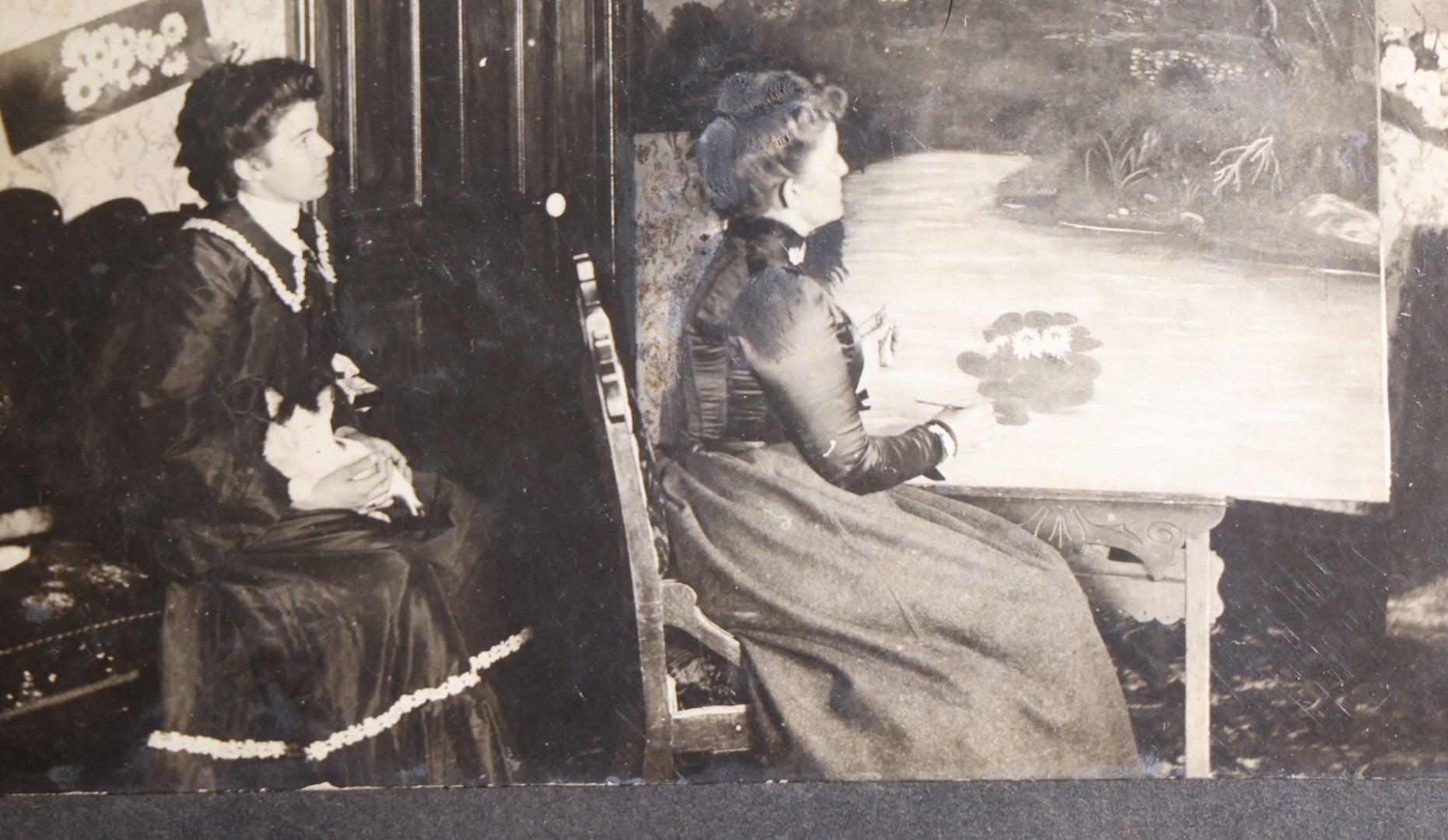 Lot 136 - Antique Board-Mounted Occupational Photograph Of A Woman Painting A Landscape At An Easel In A Parlor, Second Woman With Cat In Lap, Pencil-Inscribed "Lorna Penfold And Her Momma"