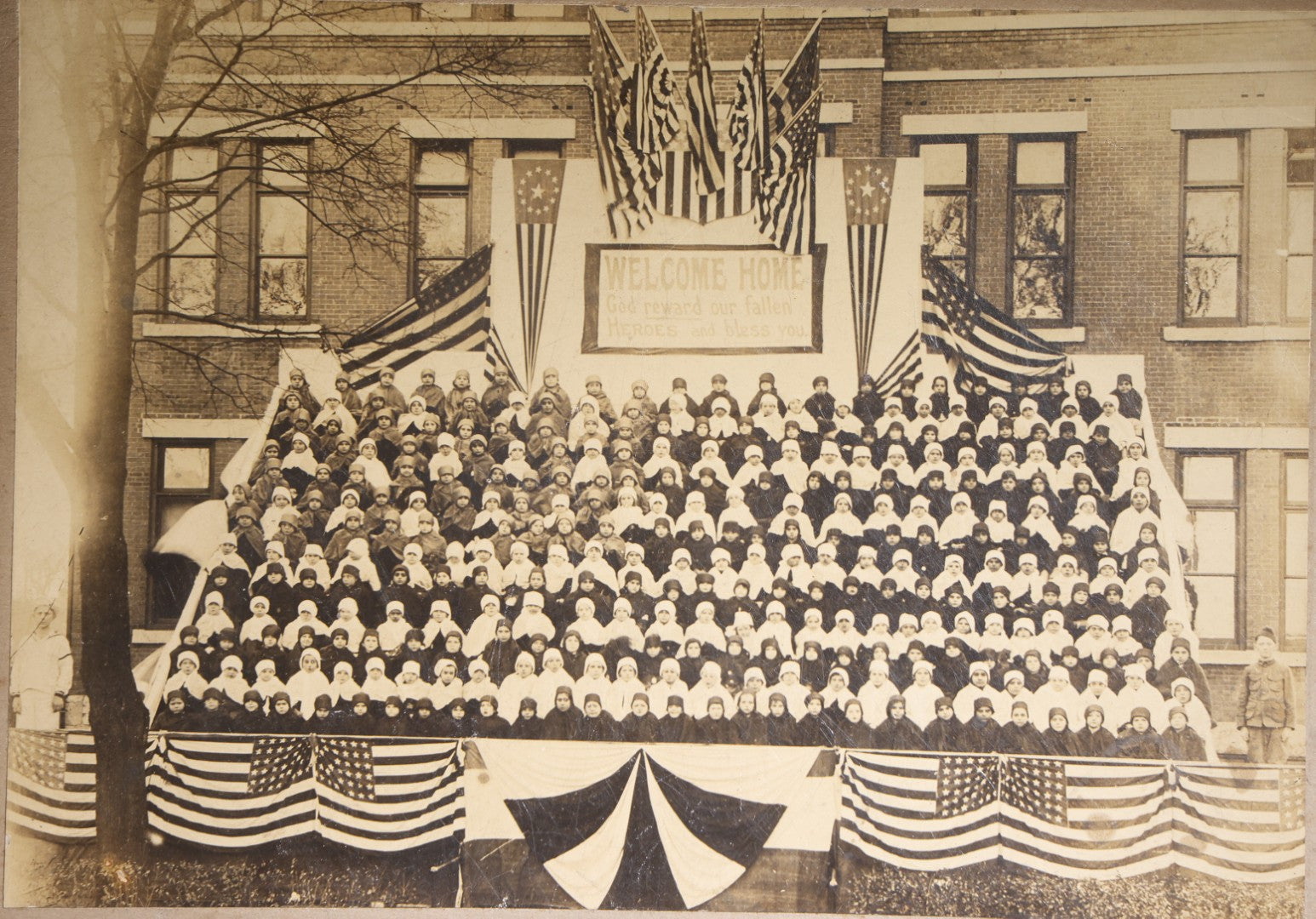 Lot 138 - Antique Board-Mounted Photograph Of Children Posed On Steps Of A Brick Building With WWI "Welcome Home" Banner, American Flags, And Patriotic Bunting, Photographed By Shea's Art Studio, Danbury, Connecticut