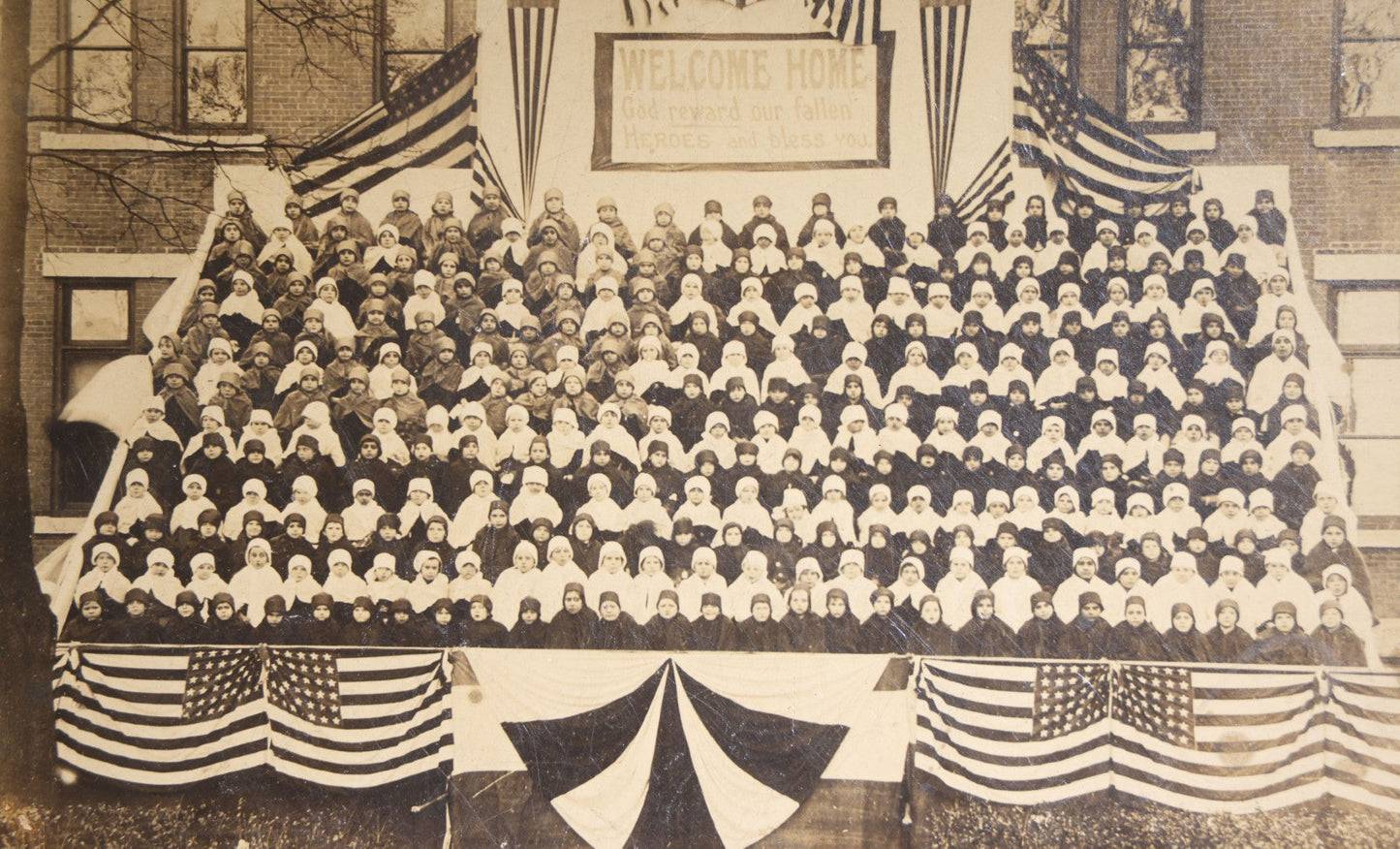 Lot 138 - Antique Board-Mounted Photograph Of Children Posed On Steps Of A Brick Building With WWI "Welcome Home" Banner, American Flags, And Patriotic Bunting, Photographed By Shea's Art Studio, Danbury, Connecticut