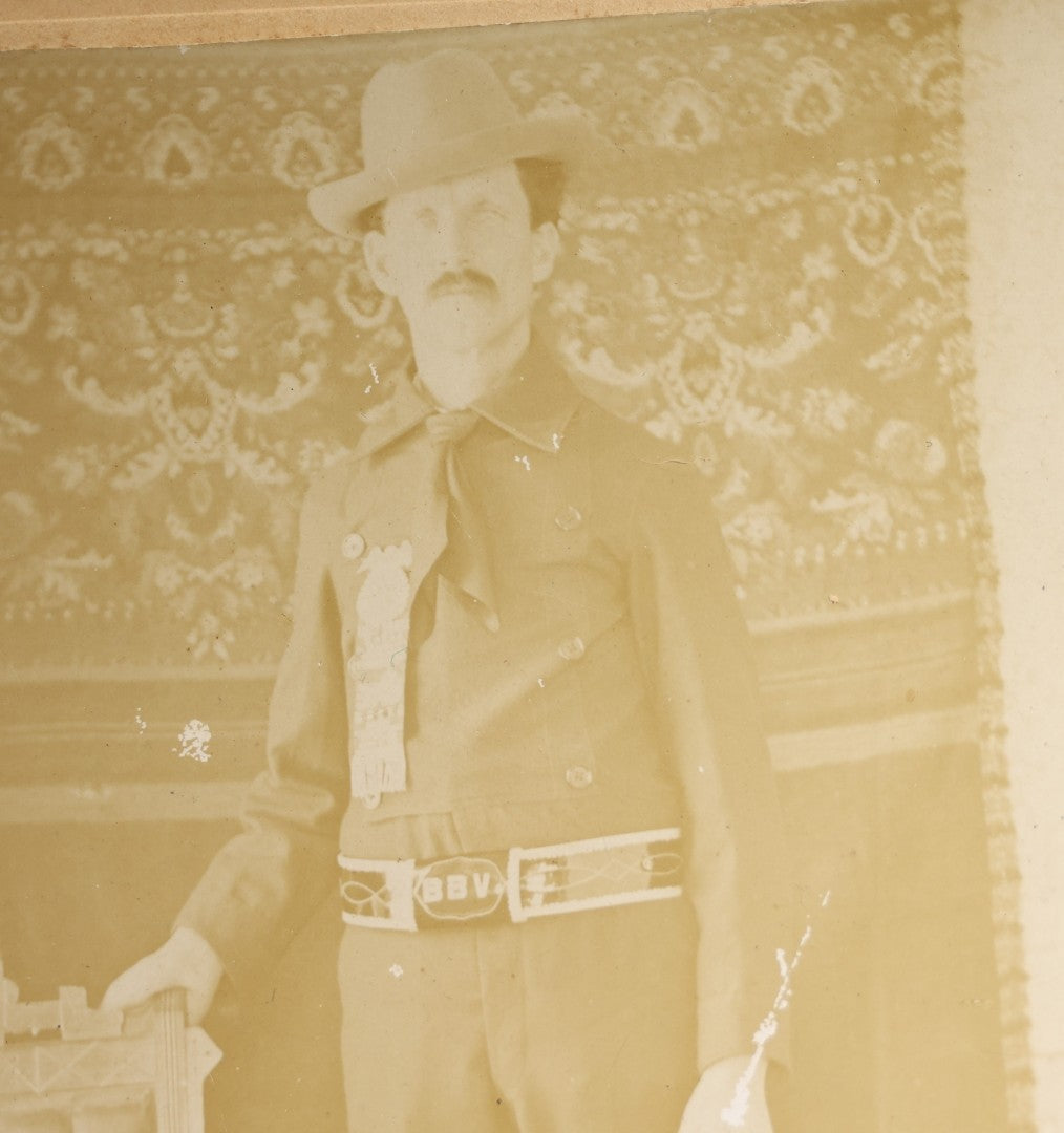 Lot 143 - Antique Board-Mounted Photograph Of A Man In Western Dress With Cowboy Hat, Decorative Shirt, And Fraternal Ribbon Badge With Eagle Device, "Bbv" Belt Buckle