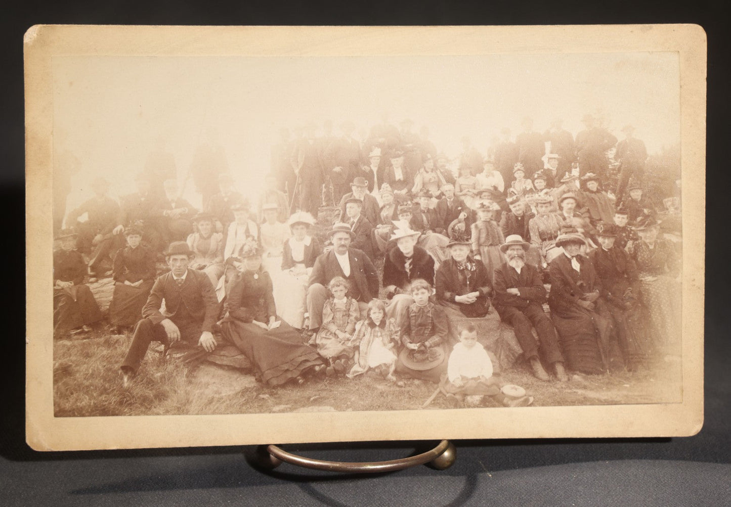 Lot 144 - Grouping Of Seven Antique Board-Mounted Photographs Of Outdoor Group Gatherings, Including Large Hillside Assembly, Men's Outing With Bottles And Basket, And Men In Aprons