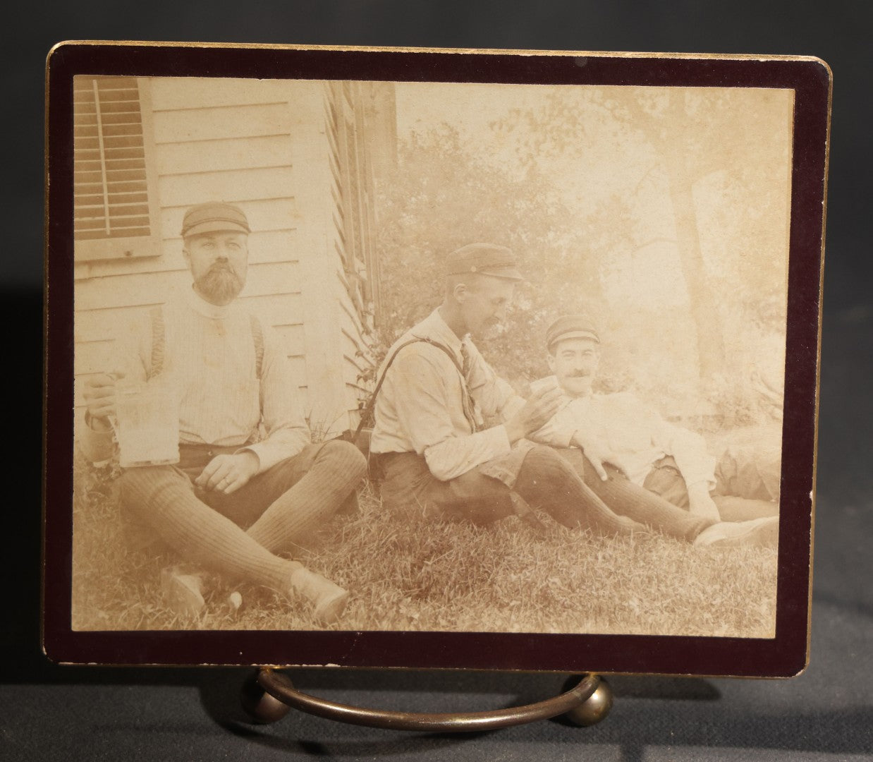 Lot 150 - Grouping Of Six Antique Board-Mounted Photographs Of Men In Social And Leisure Settings, Including Early Automobile Group, City Street Scene With Jackson Sign, Men In Hammock On Porch, And Outdoor Picnic Party