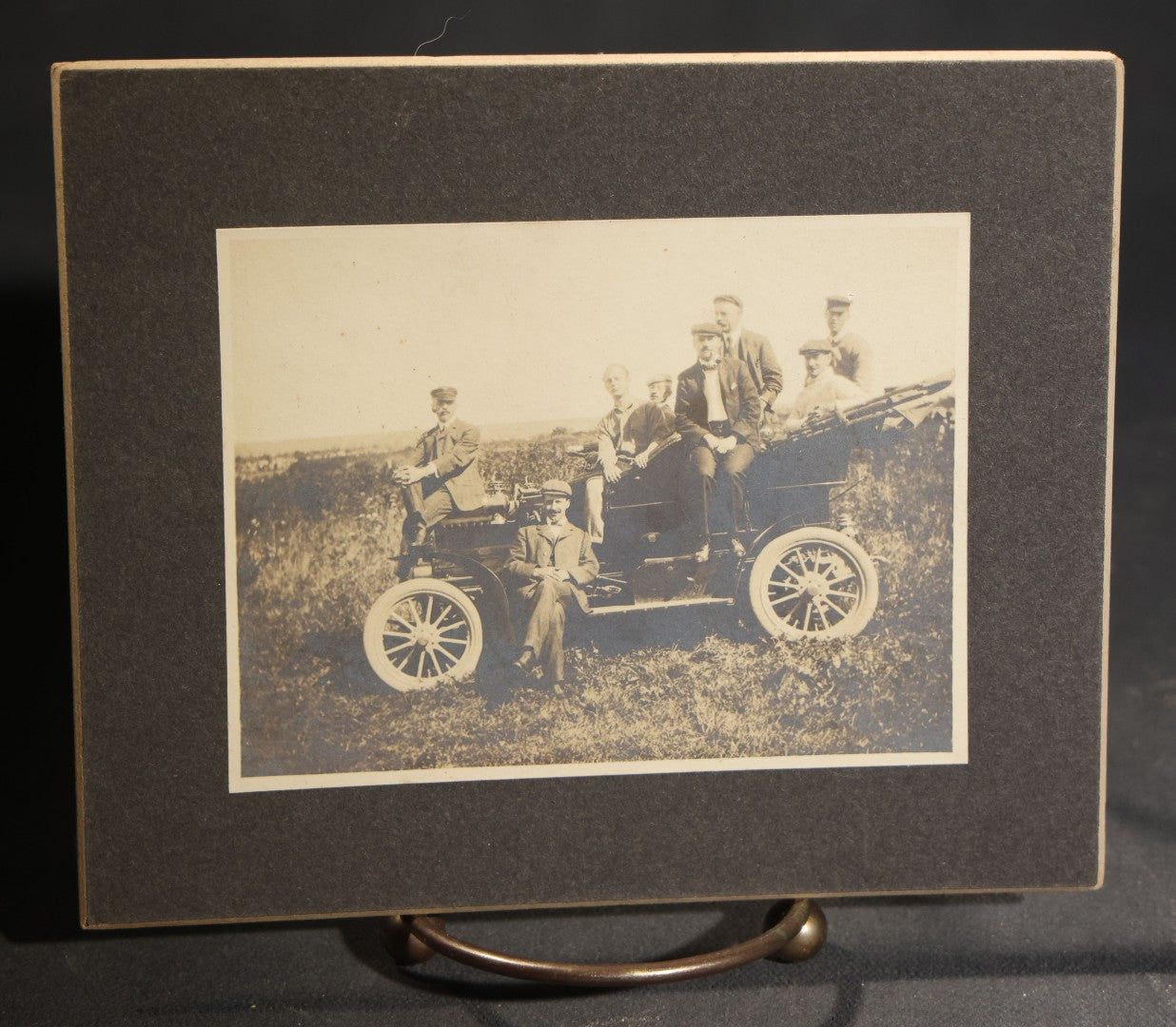 Lot 150 - Grouping Of Six Antique Board-Mounted Photographs Of Men In Social And Leisure Settings, Including Early Automobile Group, City Street Scene With Jackson Sign, Men In Hammock On Porch, And Outdoor Picnic Party