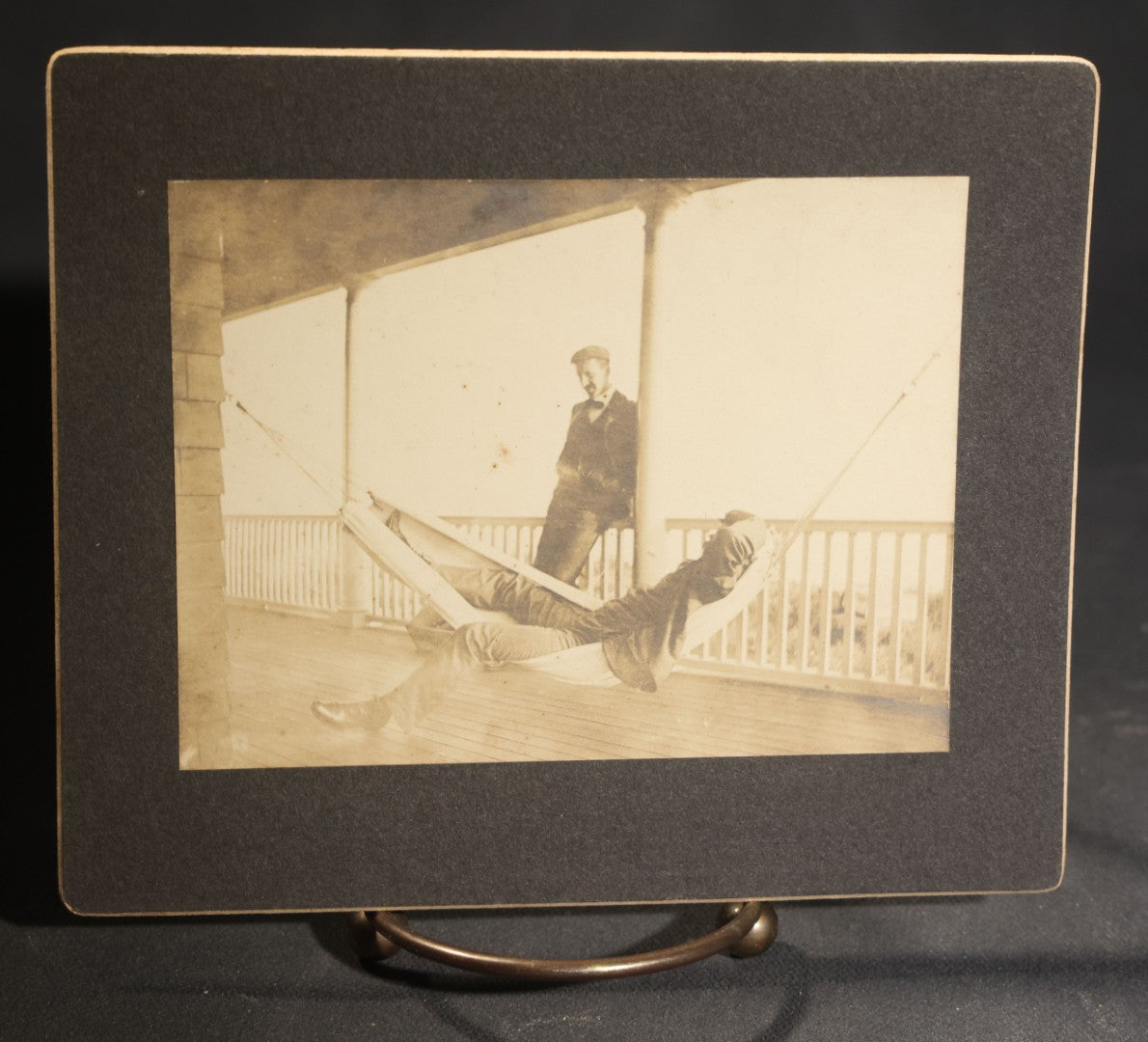 Lot 150 - Grouping Of Six Antique Board-Mounted Photographs Of Men In Social And Leisure Settings, Including Early Automobile Group, City Street Scene With Jackson Sign, Men In Hammock On Porch, And Outdoor Picnic Party