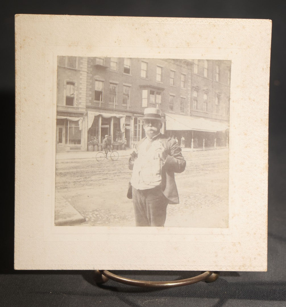 Lot 150 - Grouping Of Six Antique Board-Mounted Photographs Of Men In Social And Leisure Settings, Including Early Automobile Group, City Street Scene With Jackson Sign, Men In Hammock On Porch, And Outdoor Picnic Party