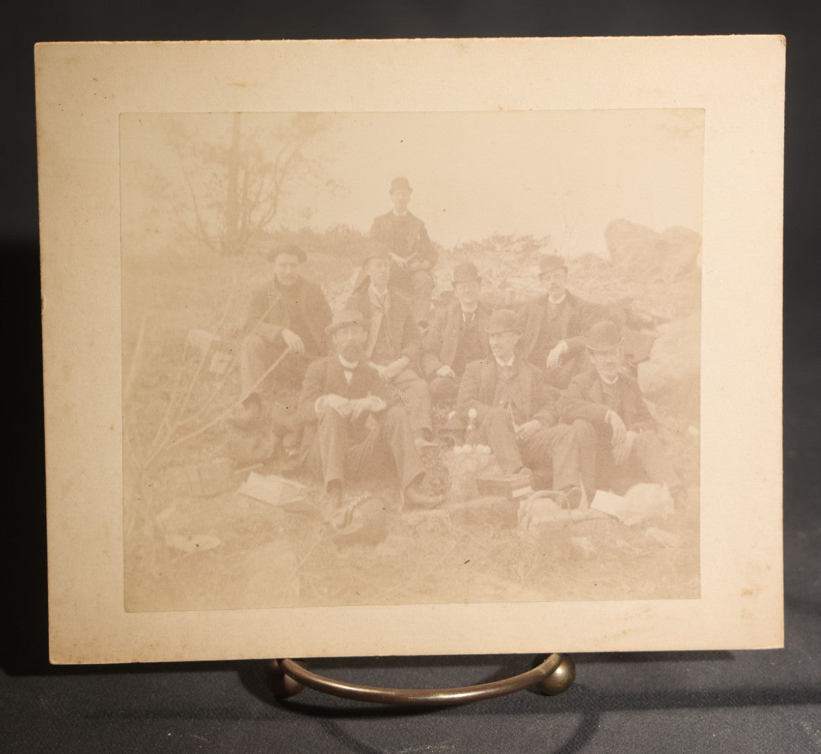 Lot 150 - Grouping Of Six Antique Board-Mounted Photographs Of Men In Social And Leisure Settings, Including Early Automobile Group, City Street Scene With Jackson Sign, Men In Hammock On Porch, And Outdoor Picnic Party