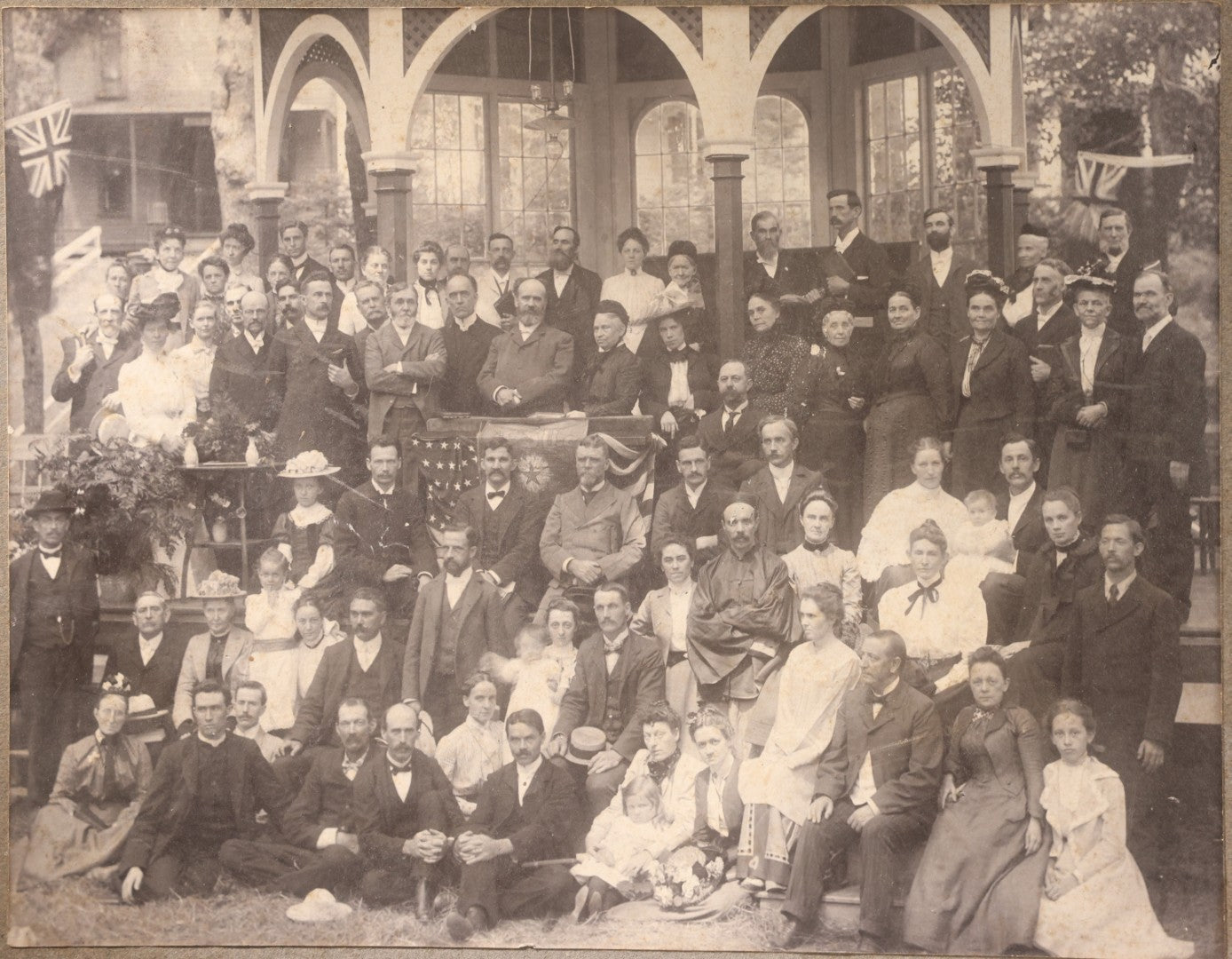 Lot 151 - Trio Of Antique Board-Mounted Group Photographs Including Large Gathering With American And British Flags At Arched Pavilion, Elderly Men In Formal Dress, And Generational Family Studio Portrait