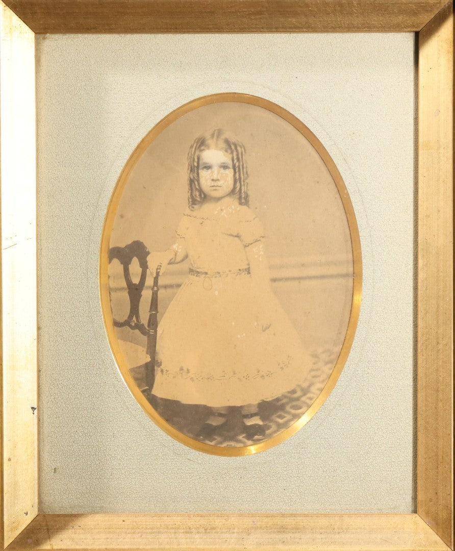 Antique Photograph of a Young Girl in a White Dress, Matted with Oval Gilt Opening, in Ebonized Inlaid Frame