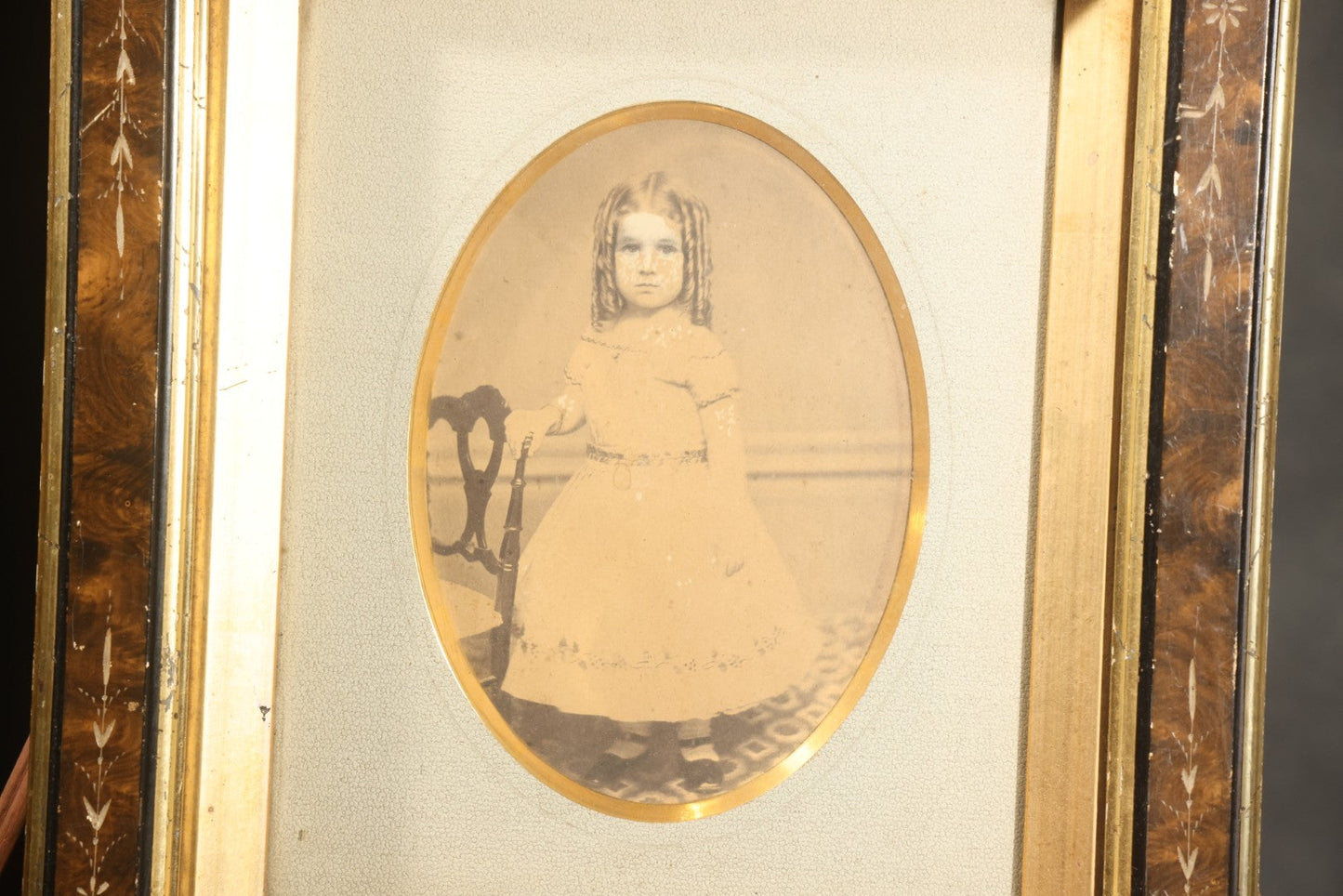 Antique Photograph of a Young Girl in a White Dress, Matted with Oval Gilt Opening, in Ebonized Inlaid Frame