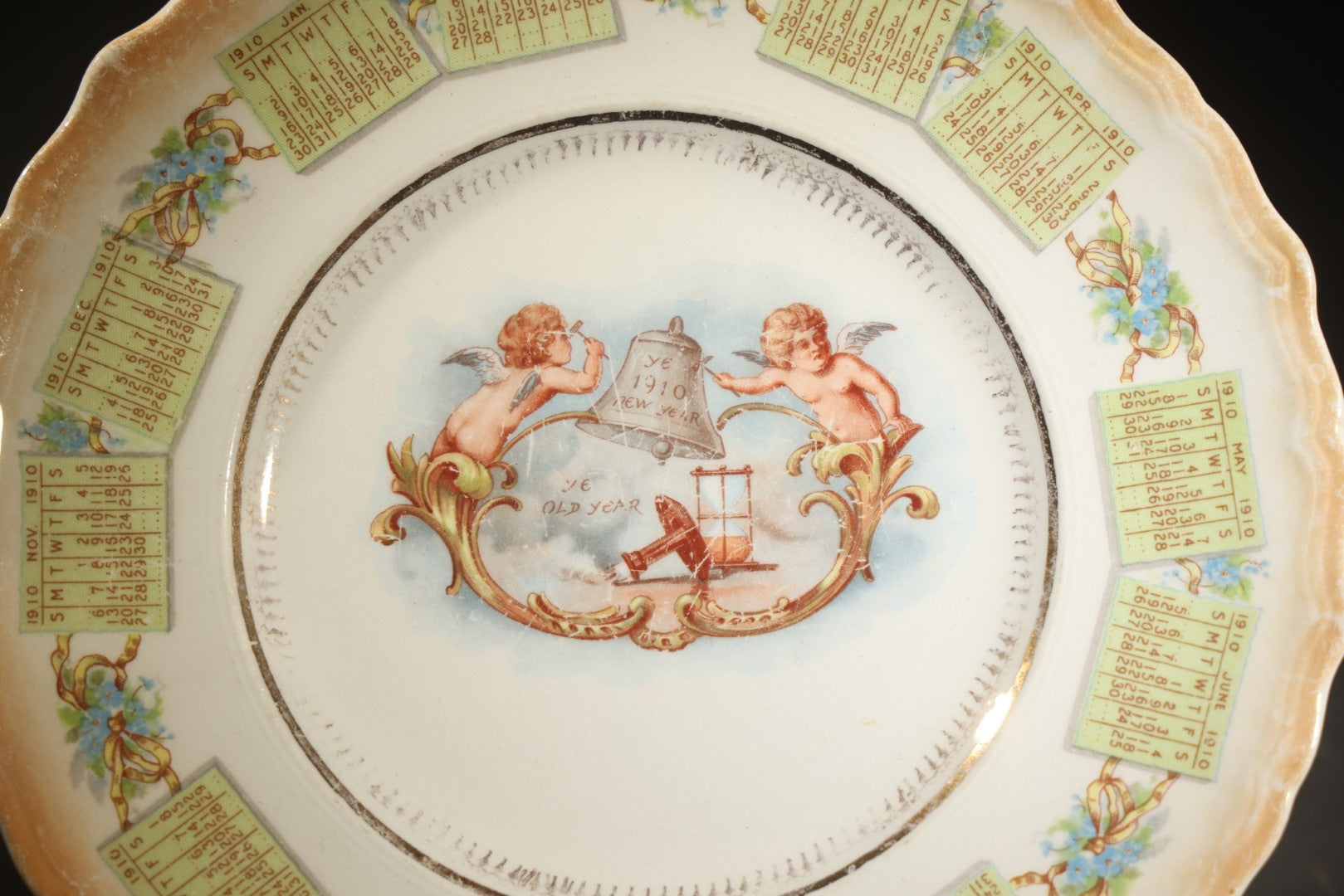 Antique Porcelain 1910 Calendar Plate with Cherubs, New Year Bell, and Hourglass Motif, Note Chip to Lower Center Rim