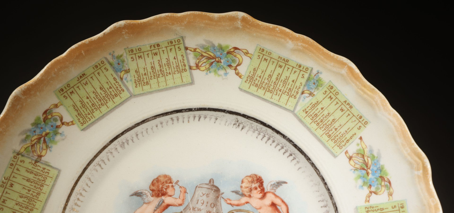 Antique Porcelain 1910 Calendar Plate with Cherubs, New Year Bell, and Hourglass Motif, Note Chip to Lower Center Rim